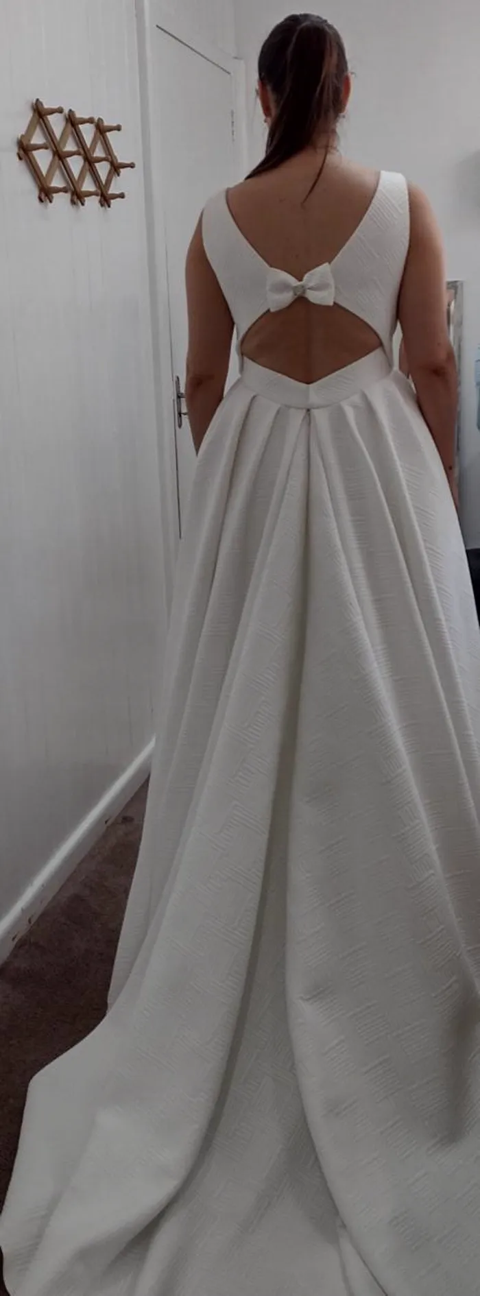 Vestido de noiva pronto, sendo usado, com laço nas costas